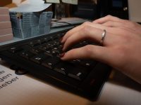 weibliche Hand tippt auf Tastatur